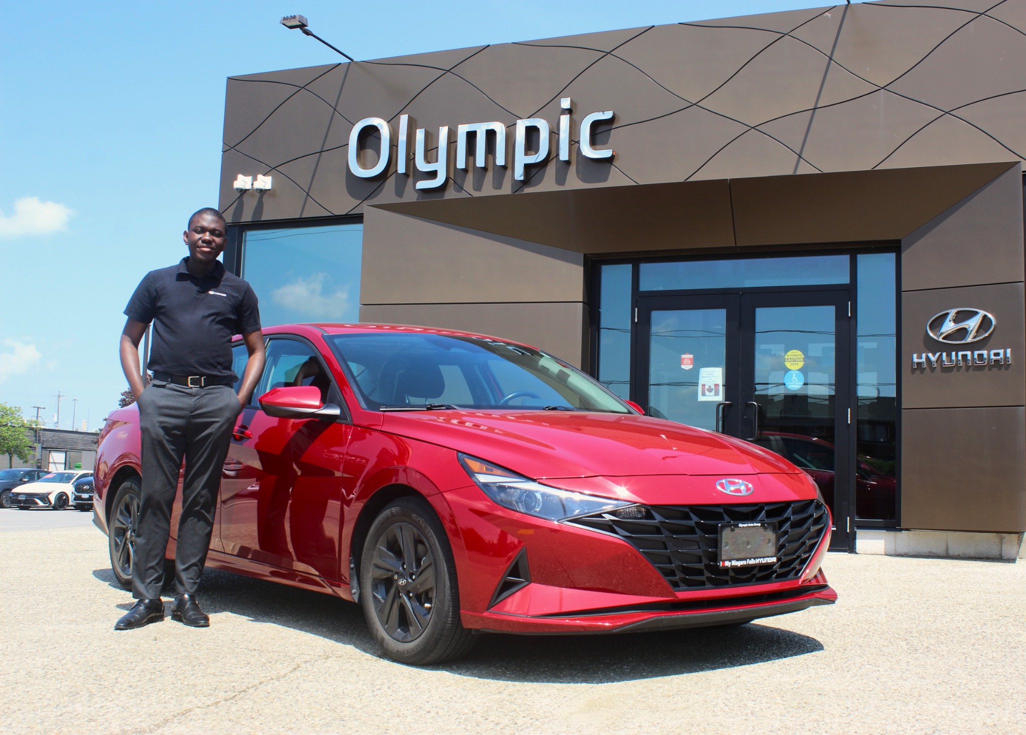Ife Solomon beside a red Hyundai Elantra at Olympic Hyundai
